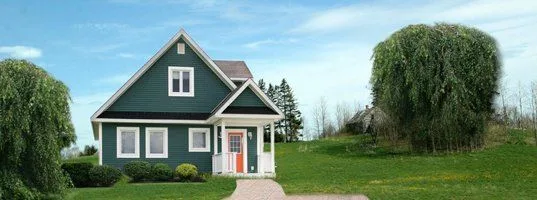 A blue house with a red door and green lawn
