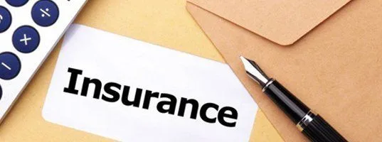 Insurance card beside a pen and envelope